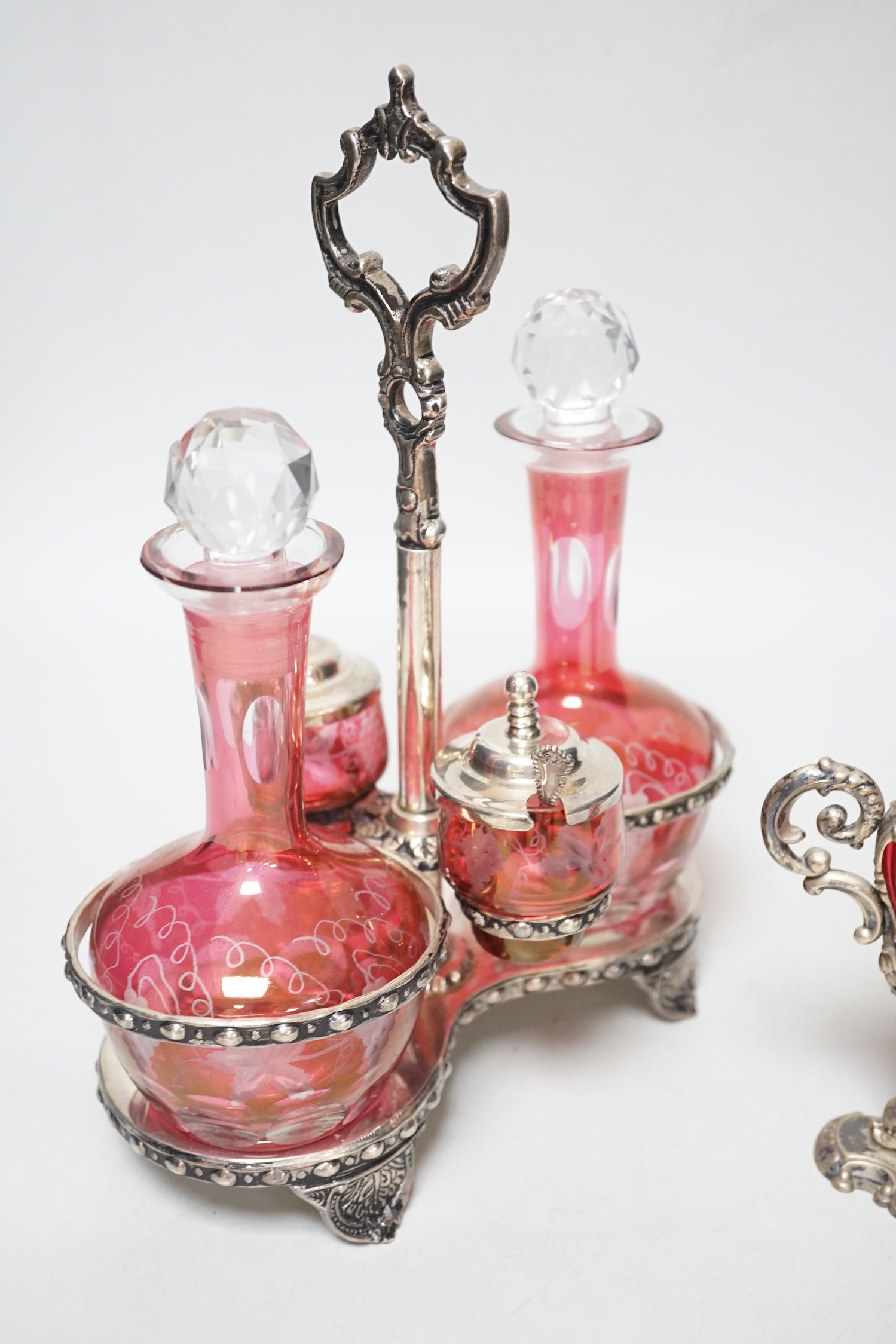 A plated cranberry two bottle and two cruet stand and a similar plated and cranberry mustard, stand 29cm high